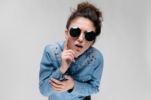 Jeune fille brune à lunettes rondes.