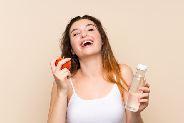 Jeune fille brune avec une pomme et une bouteille d'eau