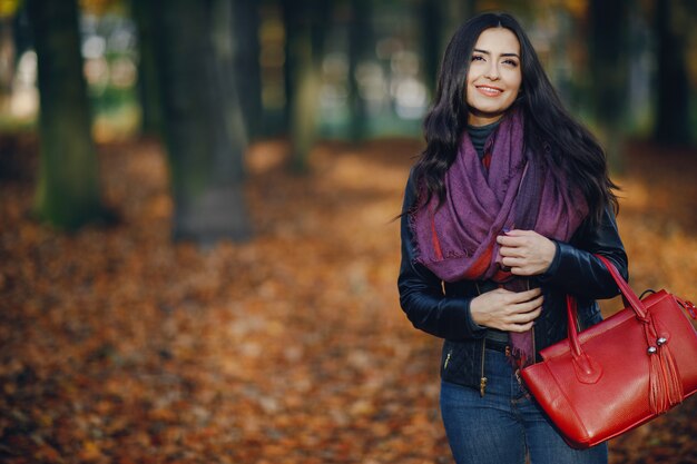 jeune fille brune se détendre au parc pendant l&#39;automne