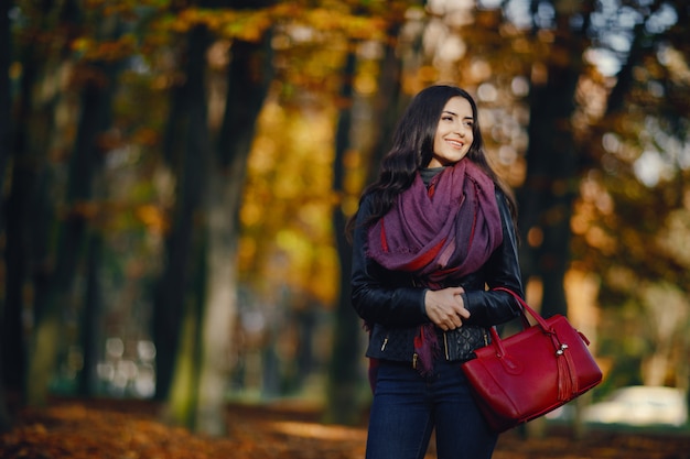 jeune fille brune se détendre au parc pendant l&#39;automne