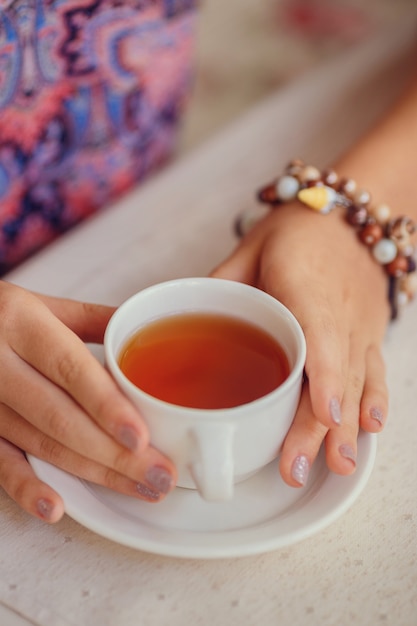 Une jeune fille buvant du thé dans un café