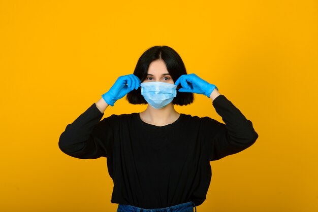 La jeune fille caucasienne dans un masque de protection de couleur bleue.