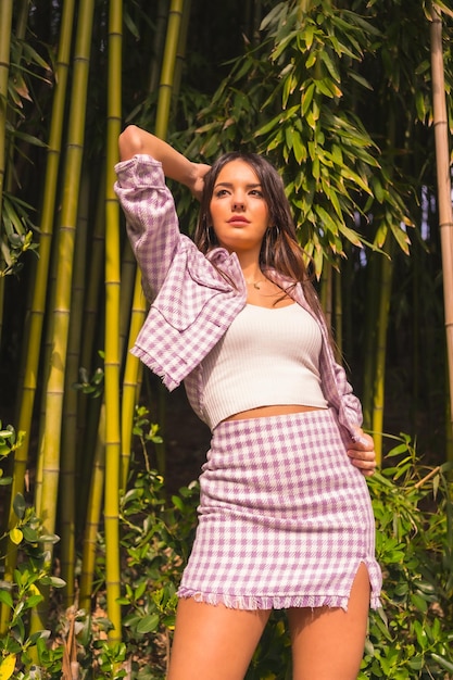 Jeune fille caucasienne avec une jupe rose dans une forêt de bambous Profitant de la ville en vacances d'été dans un climat tropical style de vie d'une jeune fille dans une pose à la mode