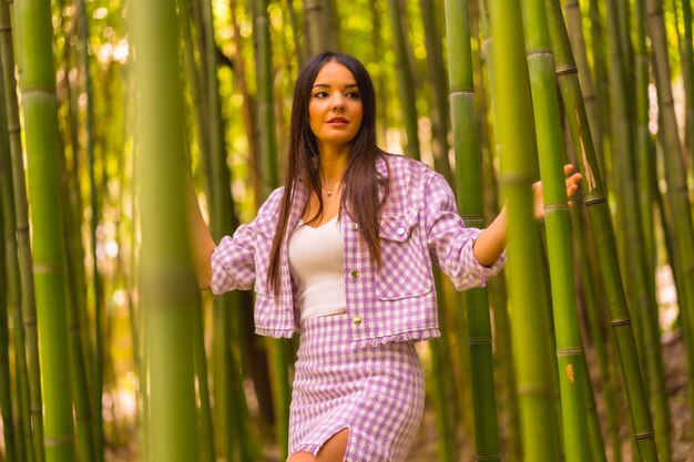 Jeune fille caucasienne avec une jupe rose dans une forêt de bambous Profiter de la ville pendant les vacances d'été dans un style de vie au climat tropical d'une fille marchant à travers la belle forêt