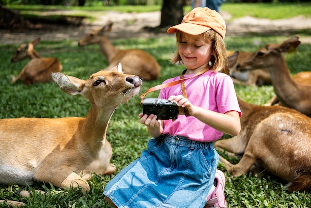 Jeune fille caucasienne prenant selfie avec des cerfs au zoo