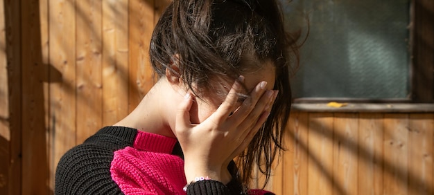 Une jeune fille caucasienne qui se couvre le visage.