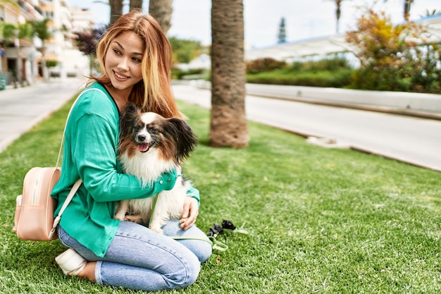 Jeune fille caucasienne souriante heureuse tenant un chien à la ville