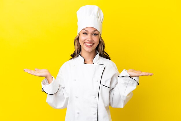 Jeune fille de chef russe isolée sur fond jaune avec une expression faciale choquée