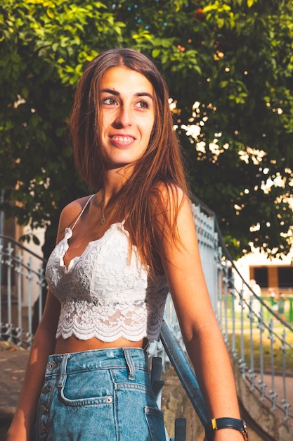 Jeune fille avec une chemise blanche et un jean court bleu