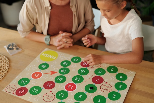 Photo jeune fille en chemise de pentecôte déplaçant la puce le long du papier avec des cercles multicolores