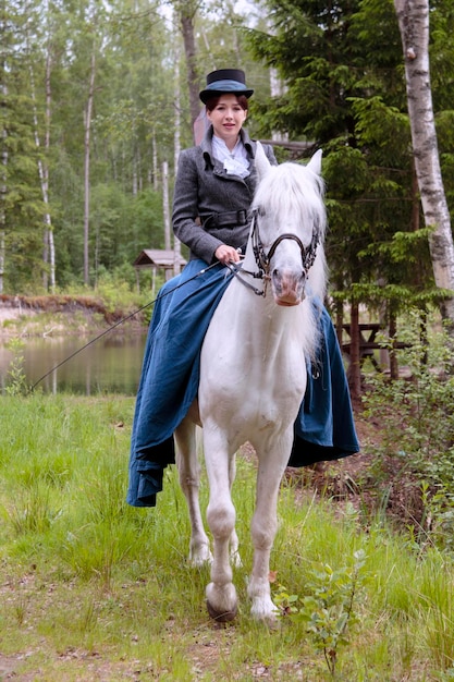 Jeune fille sur un cheval marchant dans les bois