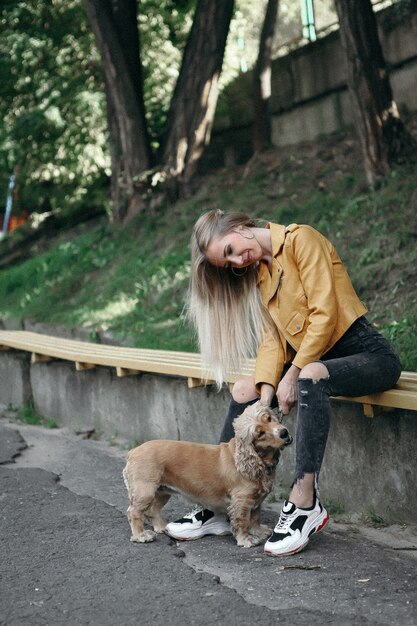 Jeune fille avec un chien se promène dans le parc