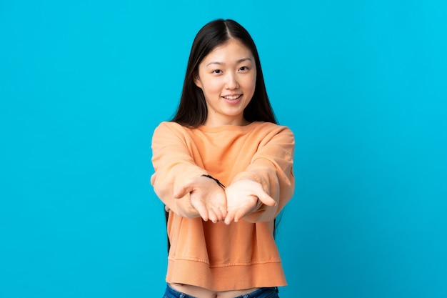 Photo jeune fille chinoise étirant ses mains vers l'avant