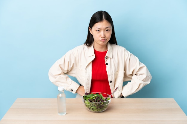 Jeune fille chinoise mangeant une salade en colère