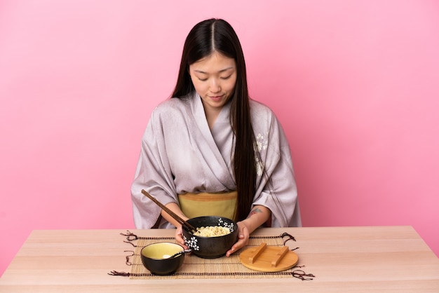 Jeune fille chinoise portant un kimono et manger des nouilles