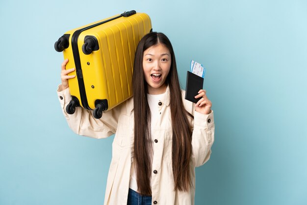 Jeune fille chinoise en vacances avec valise et passeport