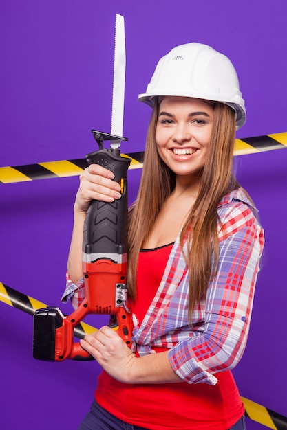 jeune fille de constructeur en chemise à carreaux, casque et jeans