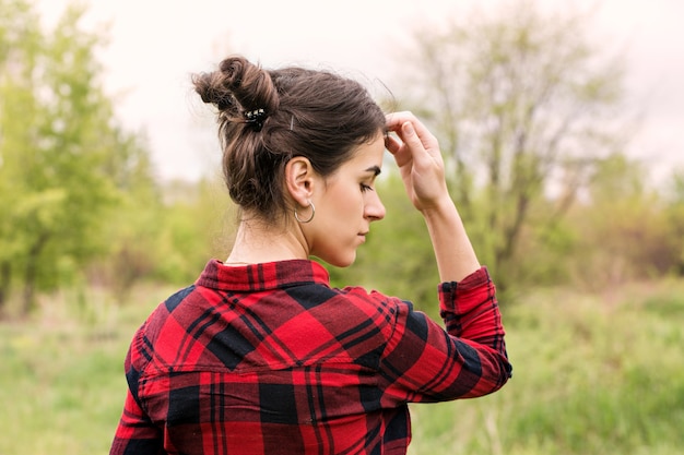 Une jeune fille avec des cornes de cheveux va sur le pré