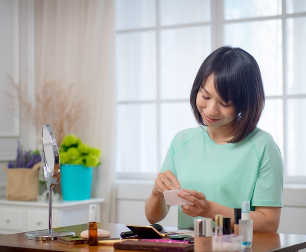 Jeune fille avec des cosmétiques de maquillage