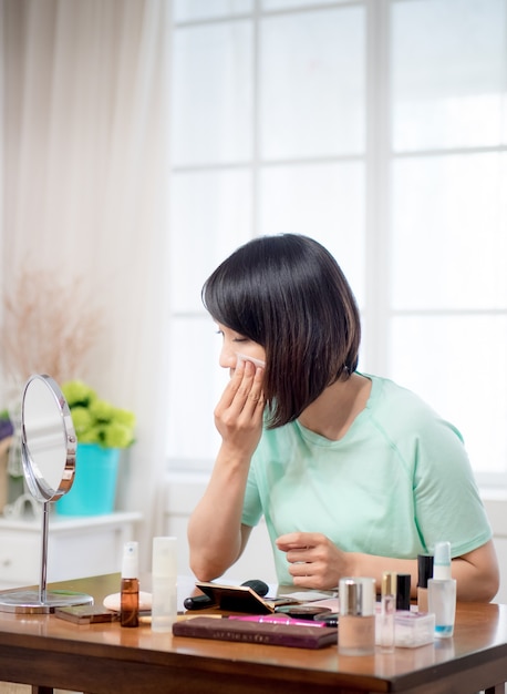 Jeune fille avec des cosmétiques de maquillage