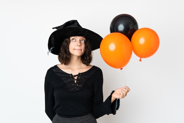 Jeune fille en costume d'Halloween sur mur blanc