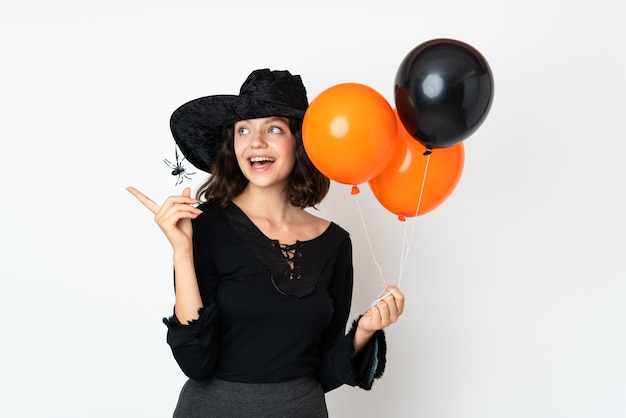 Jeune fille en costume d'Halloween sur mur blanc