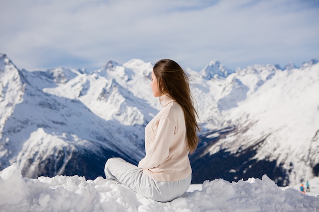 jeune fille en costume d'hiver en regardant les montagnes