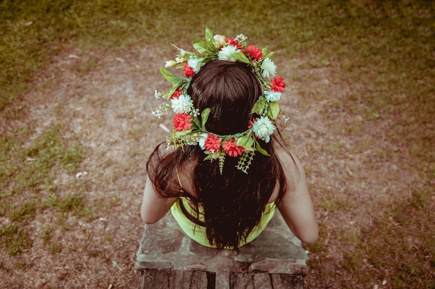 Jeune fille avec une couronne de fleurs au paysage naturel