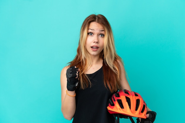 Jeune fille cycliste sur fond bleu isolé célébrant une victoire en position de vainqueur