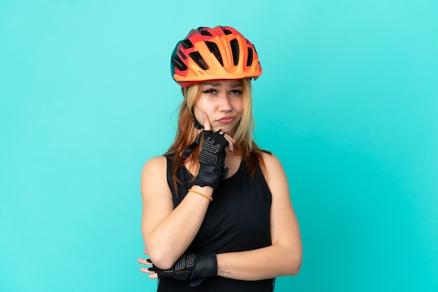 Jeune fille cycliste sur fond bleu isolé et pensée