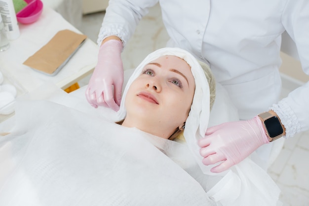 Une jeune fille dans un bureau de cosmétologie subit des procédures de rajeunissement de la peau du visage. Cosmétologie.