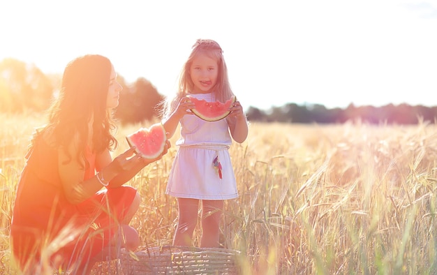 Jeune fille dans un champ de blé. Paysage d'été et une fille en promenade dans la nature. Repos au village.