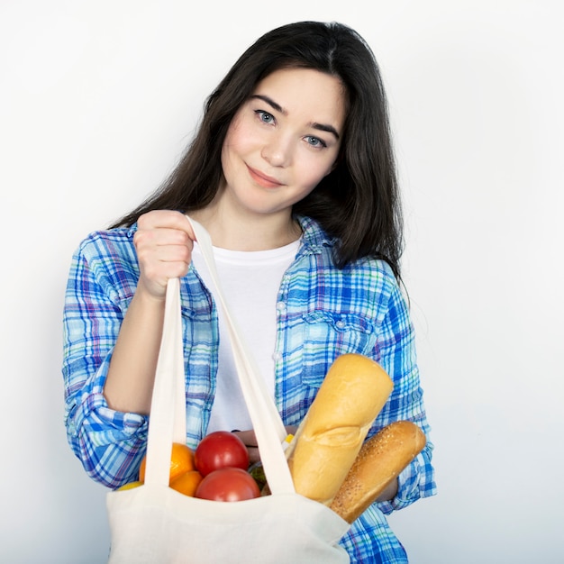 Une jeune fille dans une chemise bleue est titulaire d'un sac en tissu avec de la nourriture