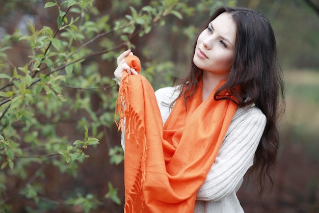 jeune fille dans une écharpe orange lors d'une promenade dans le parc