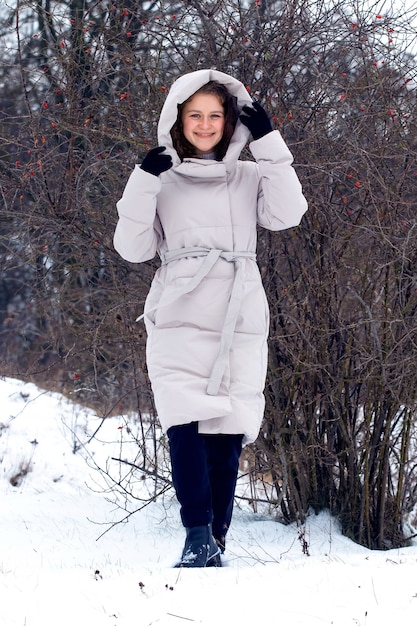 Jeune fille dans la forêt d'hiver. Portrait d'une jeune fille heureuse dans la forêt d'hiver