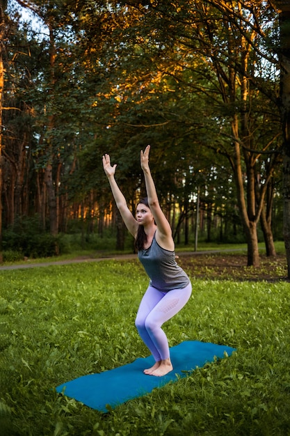 Jeune fille dans la nature, faire du yoga dans la pose de Park Utkatasana