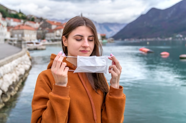 Jeune fille dans la rue de la ville portant un masque protecteur pour la propagation de la maladie à coronavirus