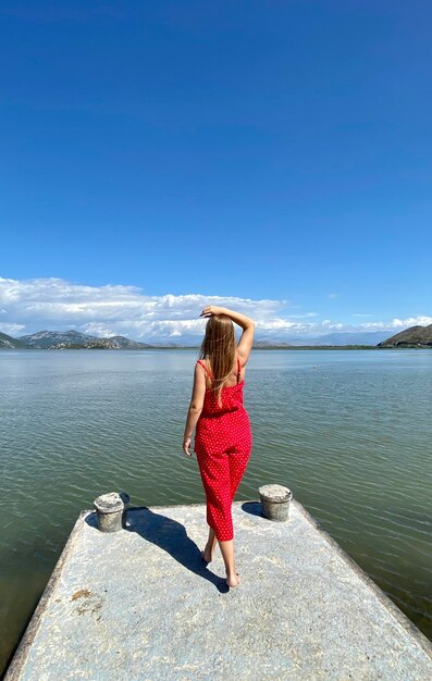 Jeune fille dans un vêtement rouge à la mode profitant de la beauté de la nature aventure relaxante incroyable
