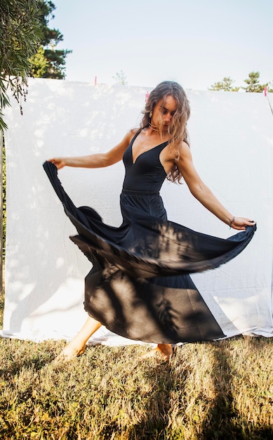 Une jeune fille dansant avec le mouvement dans le jardin pieds nus photo verticale