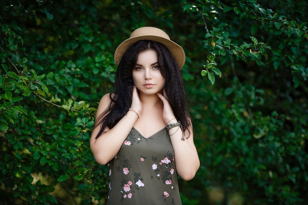 Jeune fille debout près des feuilles. Cosmétiques naturels. Beau visage de femme avec plante verte