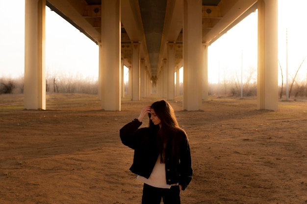 Une jeune fille debout sous le pont concept de vacances et de liberté