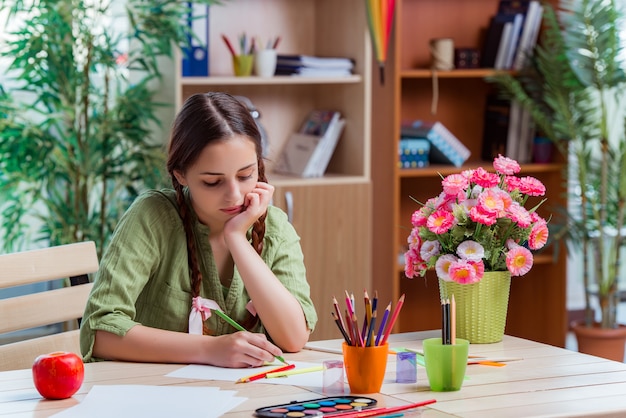 Jeune fille dessine des images à la maison