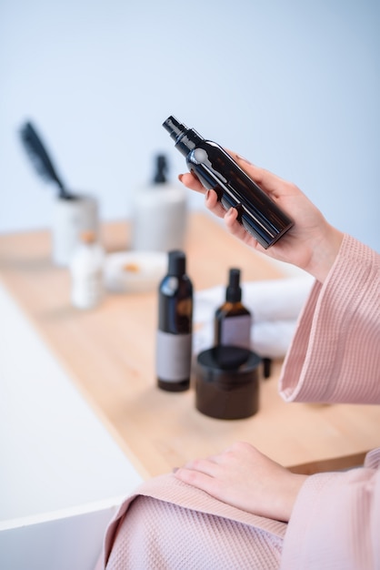 La Jeune Fille Détient Un Produit De Soins Capillaires.