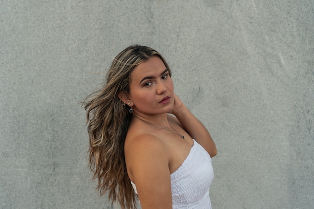 Jeune fille devant un mur gris portant une robe