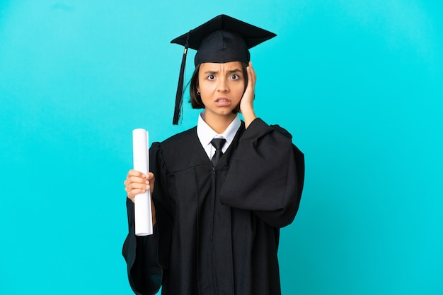 Jeune fille diplômée universitaire sur fond bleu isolé avec une expression de frustration et de ne pas comprendre