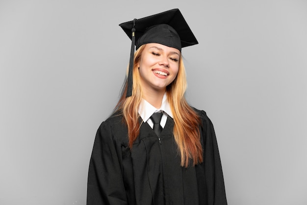 Jeune fille diplômée universitaire sur fond isolé en riant