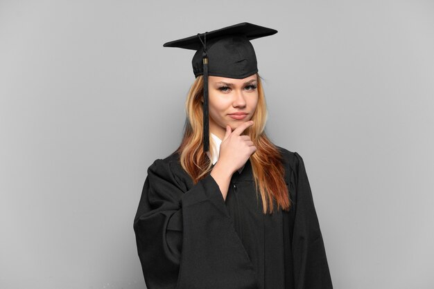 Jeune fille diplômée de l'université sur la pensée de fond isolé