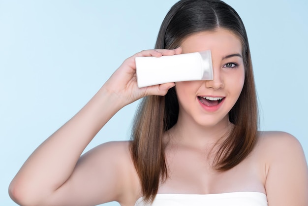 Jeune fille dodue charmante avec un tube de lotion de maintien de beauté naturelle