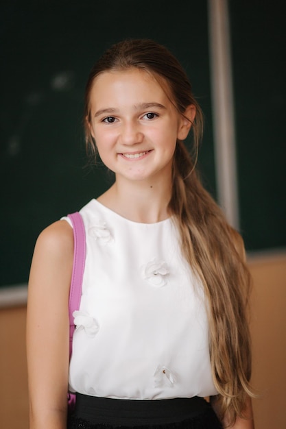 Jeune fille à l'école belle femme debout devant le tableau noir