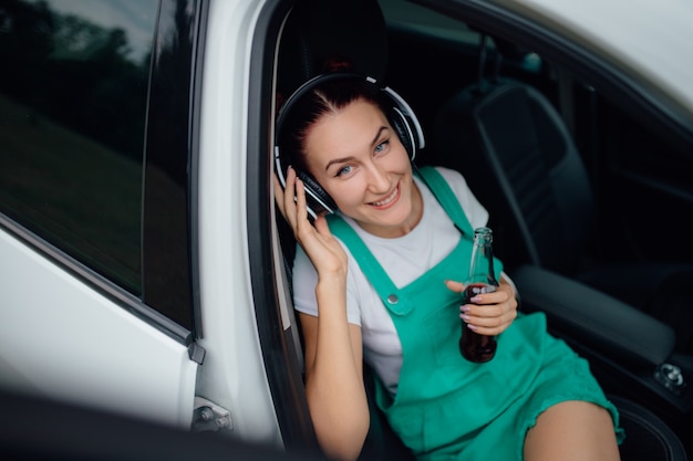 Jeune fille, à, écouteurs, écouter musique, côté, voiture